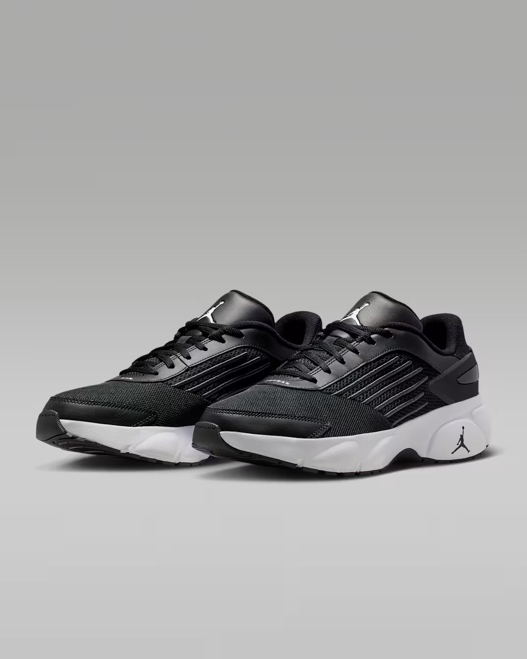 Black athletic shoes with a brand logo on a gray background